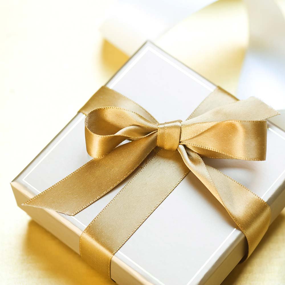 A white Barclay House gift box tied with a gold satin ribbon and bow.