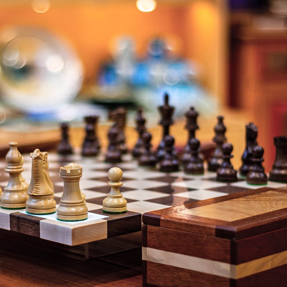 A chess set with white pieces in the foreground and dark pieces in the background on a checkered board, perfect for guests relaxing at a bed and breakfast in Vancouver, BC.