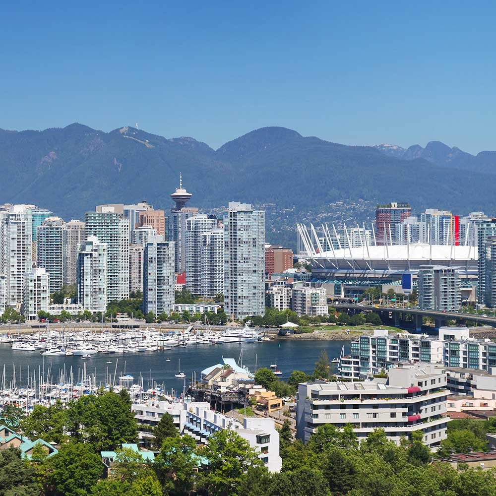 Vancouver skyline view featuring BC Place, a boat-filled harbor, and distant mountains, as seen from a Bed and Breakfast in Vancouver BC.